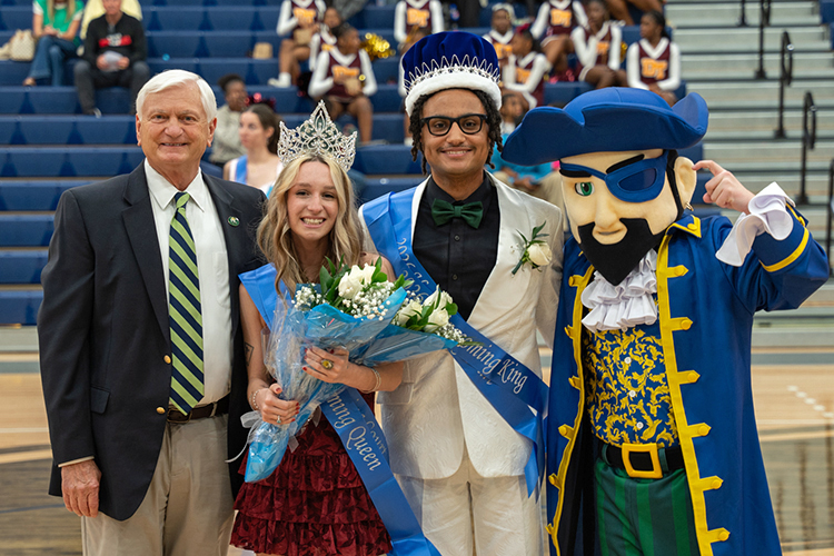 Decorative image of Dr. Meadows with e 2026 Homecoming King, Queen and Pete the Pirate.