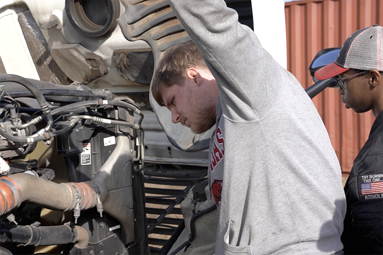 Photo of PSC students working on a diesel engine
